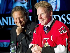 Ottawa Senators owner Eugene Melnyk looks on as Daniel Alfredsson responds to a question during a news conference in 2014. (CP)