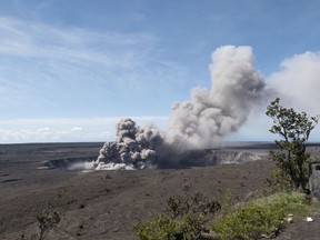 In this Friday, May 11, 2018 photo released by the U.S. Geological Survey, a weak ash plume rises from the Overlook Vent in Halema'uma'u crater of the Kilauea volcano on the Big Island of Hawaii.