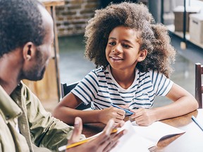 Girl talking to father at kitchen table