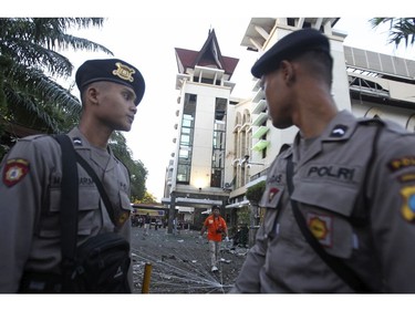 Officers stand guard at the site of an attack outside a church in Surabaya, East Java, Indonesia, Sunday, May 13, 2018.