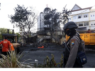 A police officer stands guard at one of the sites of church attacks in Surabaya, East Java, Indonesia, Sunday, May 13, 2018.