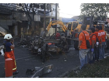 Officers remove wreckage of vehicles at the site of an attack,  in Surabaya, East Java, Indonesia, Sunday, May 13, 2018.