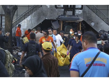 Officers carry a body bag at one of the sites of an attack in Surabaya, East Java, Indonesia, Sunday, May 13, 2018.