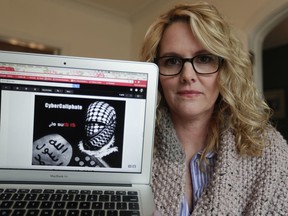 In this Monday, April 9, 2018, photo, Angela Ricketts poses with a screen shot of a message she received from a group claiming to be Islamic State supporters, in Bloomington, Ind. Russian spies masqueraded as Islamic State supporters to threaten vocal spouses of U.S. military personnel, including Ricketts, The Associated Press has found.