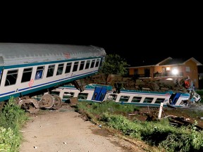 Derailed train cars sit after a regional train plowed into a big-rig truck that stopped on the tracks, in Caluso, outside Turin, Italy, early Thursday, May 24, 2018.