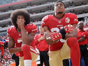 In this Oct. 2, 2016, file photo, San Francisco 49ers quarterback Colin Kaepernick, left, and safety Eric Reid kneel during the national anthem before an NFL football game against the Dallas Cowboys in Santa Clara, Calif.
