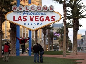 In this Feb. 12, 2009, file photo, tourists take pictures in front of the Las Vegas welcome sign.