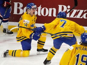 Sweden forward Lias Andersson and defenseman Timothy Liljegren celebrate a goal against the United States during a semifinal in the IIHF world junior hockey championships on Jan. 4, 2018