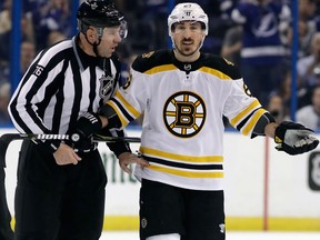 Boston Bruins left winger Brad Marchand is escorted off the ice by linesman Michel Cormier after taking a penalty against the Tampa Bay Lightning during Game 5 on May 6, 2018