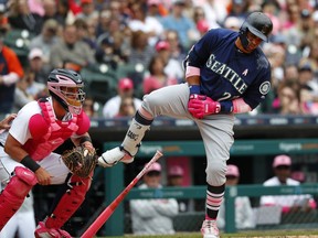 Seattle Mariners' Robinson Cano (22) reacts to being hit on the hand as Tigers catcher James McCann looks on in Detroit, Sunday, May 13, 2018.