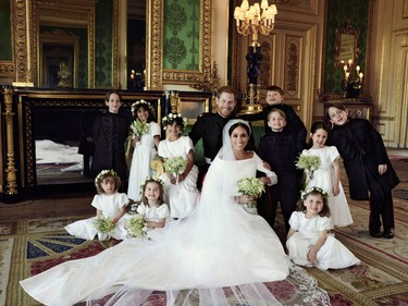 In this photo released by Kensington Palace on Monday May 21, 2018, shows an official wedding photo of Britain's Prince Harry and Meghan Markle, center, in Windsor Castle, Windsor, England, Saturday May 19, 2018. Others in photo from left, back row, Brian Mulroney, Remi Litt, Rylan Litt, Jasper Dyer, Prince George, Ivy Mulroney, John Mulroney; front row, Zalie Warren, Princess Charlotte, Florence van Cutsem.