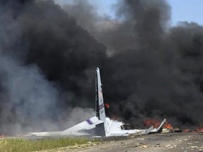 In this May 2, 2018 file photo, flames and smoke rise from an Air National Guard C-130 cargo plane after it crashed near Savannah, Ga.