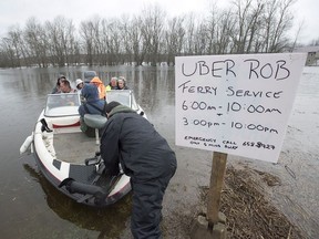 Rob Dekany, known locally as Uber Rob, ferries stranded passengers at Darlings Island, N.B. on Thursday, May 3, 2018 as the Kennebecasis River flooded the only road into the community.
