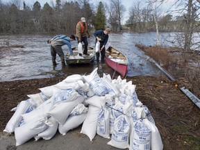 Residents transport sandbags to their homes cut off by flood waters in Rothesay, N.B. on Saturday, May 5, 2018.