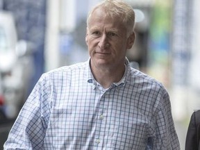 In this March 29, 2018, photo, Alfred Keating, a former Navy commodore and senior defense attache, walks towards the Auckland District Court in Auckland, New Zealand. Keating, a high-ranking New Zealand military officer, has been accused Friday, May 4, 2018, of hiding a camera in a bathroom at the nation's embassy in Washington D.C. and has been charged with attempting to make an intimate visual recording, in a case that has raised unusual jurisdictional questions.