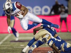 Montreal Alouettes slotback Nik Lewis, left, leaps over Winnipeg Blue Bombers defensive back Taylor Loffler (16) in Montreal on August 24, 2017. (THE CANADIAN PRESS/Paul Chiasson)