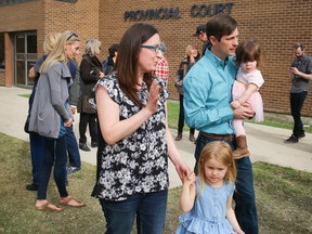 Edouard Maurice outside the Okotoks Provincial Court Building with his family. The local rancher is facing charges of aggravated assault, pointing a firearm and careless use of a firearm, following a robbery at his home on Tuesday, February 24. Al Charest/Postmedia