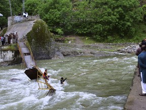 Pakistani rescue workers search for bodies at the site of bridge collapse in Kundal Shahi, some 75 kilometers (47 miles) north of Muzaffarabad, the capital of Pakistani controlled Kashmir, Sunday May 13, 2018.