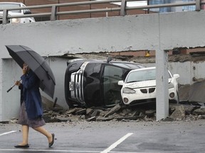 An official walks by the scene of part of a parking deck that collapsed, Thursday, May 3, 2018, in Detroit.