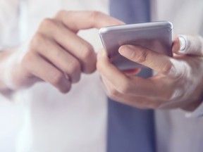 Close up of a business man using mobile smart phone.