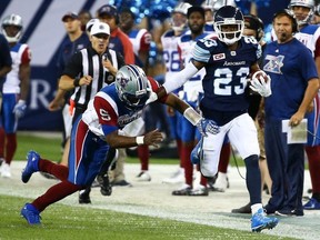 T.J. Heath of the Toronto Argos runs the ball past Kevin Glenn of the Montreal Alouettes during CFL action at BMO Field in Toronto, Ont. on Monday July 25, 2016.