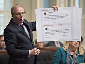 Parti Quebecois Leader Jean-Francois Lisee questions Premier Couillard on illegal migrants, displaying tweets from Prime Minister Justin Trudeau, during question period Tuesday, May 8, 2018 at the legislature in Quebec City.