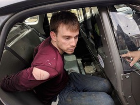 In this photo released by the Metro Nashville Police Department, Travis Reinking sits in a police car after being arrested in Nashville, Tenn., on Monday, April 23, 2018.