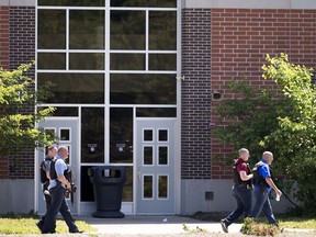 Law enforcement officers walk outside Noblesville West Middle School in Noblesville, Ind., after a shooting on Friday, May 25, 2018.