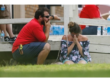 A woman prays in the grass outside the Alamo Gym where parents wait to reunite with their kids following a shooting at Santa Fe High School Friday, May 18, 2018, in Santa Fe, Texas.