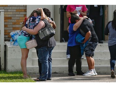 People embrace outside the Alamo Gym where students and parents wait to reunite following a shooting at Santa Fe High School Friday, May 18, 2018, in Santa Fe, Texas.