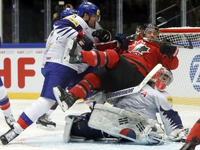 South Korea's Bryan William Young, left, hits Canada's Jaden Schwartz onto South Korea's Matt Dalton, down, during the world championship at the Jyske Bank Boxen arena in Herning, Denmark, Sunday, May 6, 2018. (AP Photo/Petr David Josek)