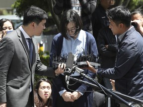 Cho Hyun-ah, center, is questioned by reporters before entering a Korea Immigration Service office for questioning in Seoul, South Korea, Thursday, May 24, 2018.