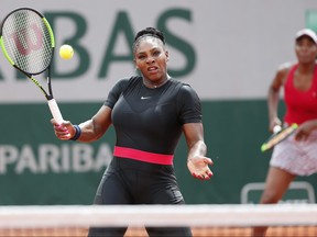 Venus, rear right, and Serena Williams return a shot against Shuko Aoyama and Miyu Kato during their first round match of the French Open tennis tournament at the Roland Garros stadium in Paris, France, Wednesday, May 30, 2018. (AP Photo/Thibault Camus)