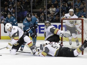 Vegas Golden Knights' Brayden McNabb, left, stops a shot in front of San Jose Sharks' Joonas Donskoi, second from left, next to Golden Knights goalie Marc-Andre Fleury, centre, and left-wing Erik Haula during the first period of Game 6 of an NHL hockey second-round playoff series Sunday, May 6, 2018, in San Jose, Calif.