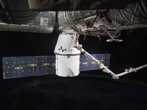 In this image obtained from NASA, the SpaceX Dragon resupply ship, with the Canadarm2 robotic arm in the foreground, is pictured installed to the Harmony module's Earth-facing port on April 5, 2018. (HO/AFP/Getty Images)