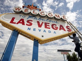 In this July 28, 2005, file photo, an electric company worker changing ballasts and lamps on the "Welcome to Las Vegas," sign in Las Vegas.