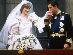Prince Charles kisses the hand of his bride Princess Diana on the balcony of Buckingham Palace on their wedding day in London, England, July 29, 1981.