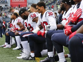 Members of the Houston Texans, including Kevin Johnson and Lamarr Houston, kneel during the national anthem before their game at CenturyLink Field on October 29, 2017 in Seattle. (Jonathan Ferrey/Getty Images)