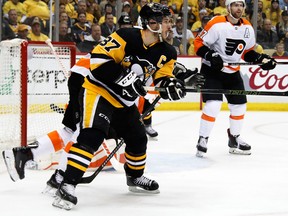 In this April 11, 2018, file photo, Pittsburgh Penguins' Sidney Crosby (87) redirects a shot past Philadelphia Flyers goaltender Brian Elliott for a goal during the second period in Game 1 of an NHL first-round hockey playoff series in Pittsburgh