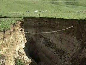 This image made from a May 2, 2018 video shows a huge sinkhole on farm in Rotorua, New Zealand.