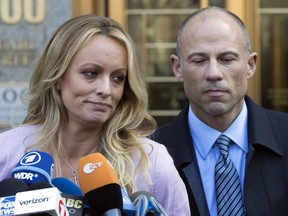 In this April 16, 2018 file photo, adult film actress Stormy Daniels, whose given name is Stephanie Clifford, and her attorney Michael Avenatti talk to reporters outside federal court in New York City.
