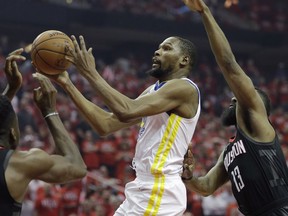 Golden State Warriors forward Kevin Durant (35) drives to the basket past Houston Rockets guard James Harden (13) during Game 1 of the NBA Western Conference Finals, Monday, May 14, 2018, in Houston.