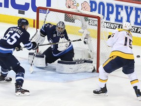 Craig Smith of the Nashville Predators shoots wide against Mark Scheifele and Connor Hellebuyck of the Winnipeg Jets in Game Three of the Western Conference Second Round during the 2018 NHL Stanley Cup Playoffs on May 1, 2018 at Bell MTS Place in Winnipeg. (Jason Halstead /Getty Images)