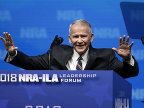 In this May 4, 2018 photo, former U.S. Marine Lt. Col. Oliver North acknowledges attendees as he gives the Invocation at the National Rifle Association-Institute for Legislative Action Leadership Forum in Dallas.