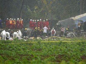 Rains begins to fall as rescue teams search through the wreckage site of a Boeing 737 that plummeted into a yuca field with more than 100 passengers on board, in Havana, Cuba, Friday, May 18, 2018.