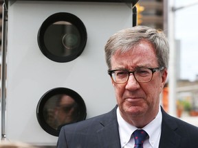 Jim Watson, Mayor of Ottawa, stands in front of a red light camera on Lyon St,  May 22, 2018.  Photo by Jean Levac/Postmedia