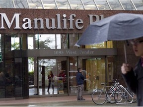A pedestrian walks past the Manulife building in downtown Vancouver, B.C., Thursday, May 3, 2012.