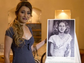 Sarah Idan, Iraq's 2017 Miss Universe beauty pageant contestant, poses with an exhibit showing 1947 Miss Baghdad Renee Dangoor, during a visit to the Babylonian Jewry Heritage Center in Or Yehuda, Israel, Thursday, June 14, 2018.