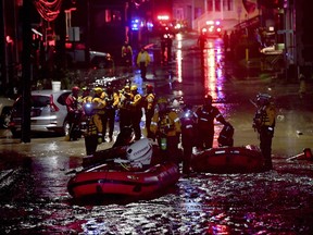 In this Wednesday, June 20, 2018, photo crews work in flood waters on Baldwin Street in Bridgeville, Pa. Strong storms containing heavy rains have caused severe flooding in parts of western Pennsylvania, spurring dozens of evacuations and damaging numerous vehicles and other property. (Matt Freed/Pittsburgh Post-Gazette via AP)