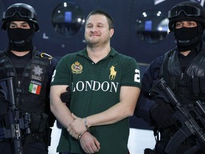 Texas-born fugitive Edgar Valdez Villarreal, also known as "La Barbie," center, reacts during his presentation to the media after his arrest in Mexico City on Aug. 31, 2010. (AP Photo/Alexandre Meneghini)